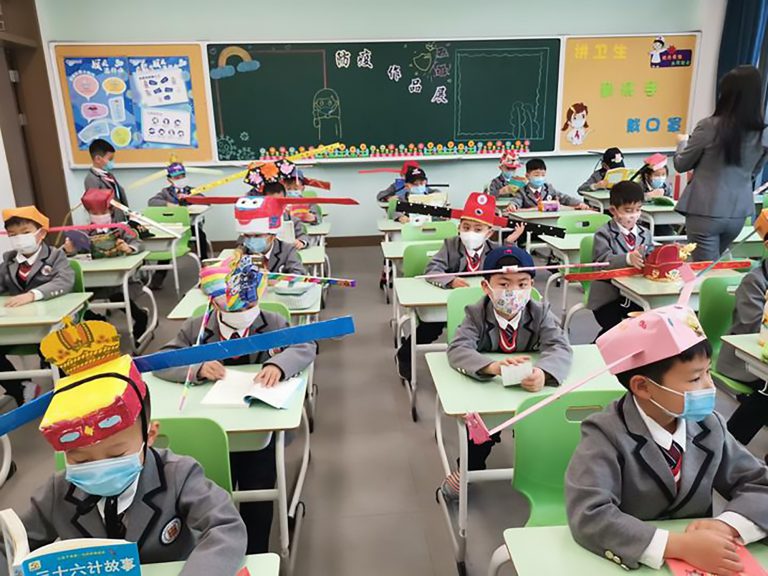 В китайской школе детей заставили носить двухметровые шляпы от коронавируса